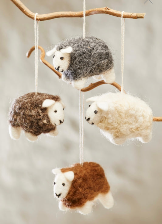 Handmade Felted Sheep Decoration £8.00  A sweet, hanging &amp; standing, woolly felt sheep with a natural coat.  Everyone will love this novelty craft decoration made from eco friendly wool &nbsp;&amp; felted by artisans in Nepal.  Just one of many super cute fair trade felts we have in store.  16 x 8.5 x 6cm (in string)  Eco friendly and Biodegradable  Available in four colours  Hand Crafted In Nepal Shop small, Shop independent, super cute gift, felting, Seawitch Stores, Mousehole, Cornwall. 